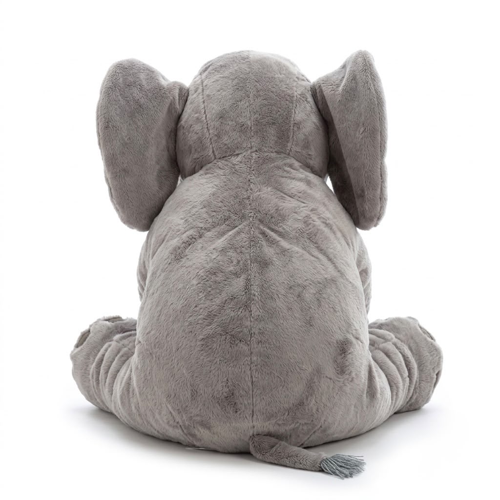 A gray plush elephant toy shown from the back, sitting with its ears wide and tail hanging down, photographed on a clean white background.