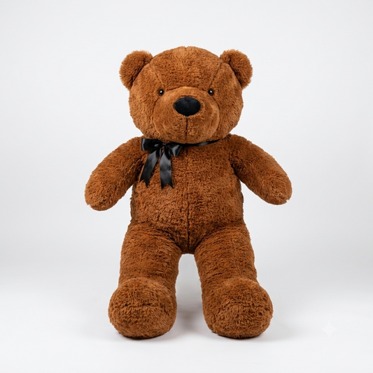 A brown plush teddy bear sitting upright against a light gray studio background, with a black satin bow tied around its neck.