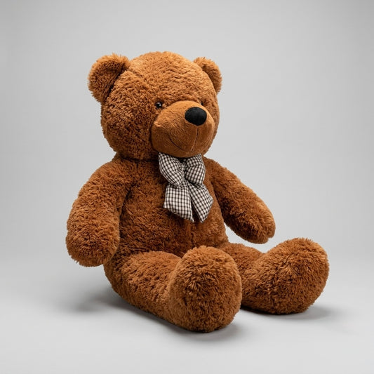 A brown plush teddy bear sitting on a light gray studio background, wearing a small black-and-white checkered bow tie.