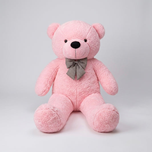 A pink plush teddy bear sitting upright against a light gray studio background, with a small black-and-white checkered bow tie at its neck.