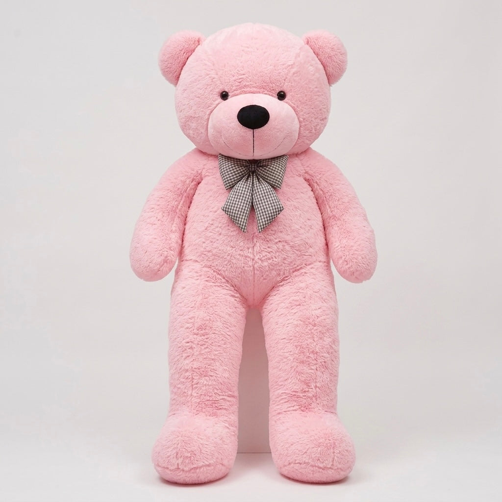 A large pink plush teddy bear standing upright against a plain light gray background, with a small gray patterned bow tie at the neck.