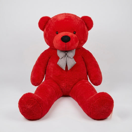 A red plush teddy bear sitting down, wearing a small gray and white checkered bow tie, photographed against a light gray studio background.