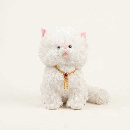 A white fluffy plush kitten toy with pink inner ears, a pink nose, black bead eyes, and a gold beaded collar with a red jewel, sitting against a plain cream background.