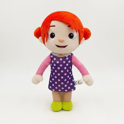 A plush doll with bright orange-red hair, a purple polka-dot dress, pink sleeves, and lime green shoes, photographed against a plain white studio background.