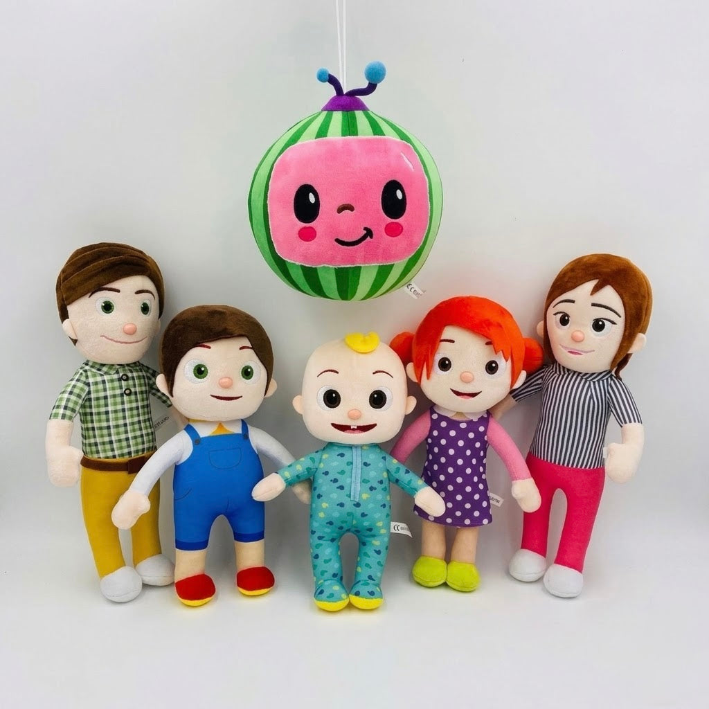 Five Cocomice plush toys and a hanging watermelon-themed balloon are arranged on a plain white studio background. The set includes a father and mother figure, two children in blue and teal outfits, a girl in a purple polka-dot dress, and a hanging green-and-white watermelon balloon with a pink smiling face.
