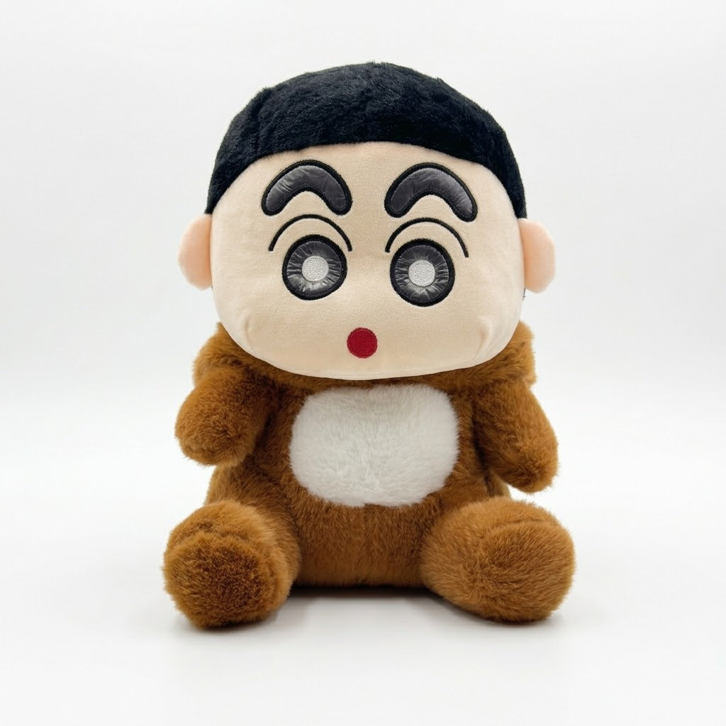 A plush toy doll with a round beige face, black hair, pink cheeks, a red nose, and a brown body with a white belly patch, photographed against a plain light gray background.