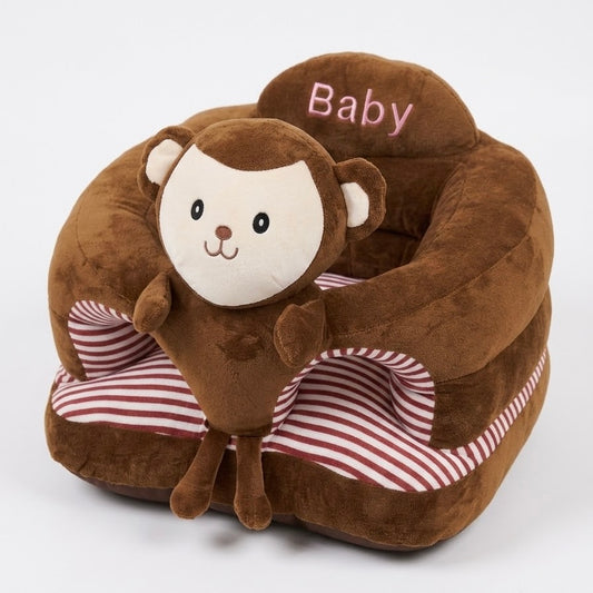 A plush baby pet bed shaped like a monkey, featuring a brown plush body with a smiling monkey face, pink embroidered 'Baby' text on the headrest, and red-and-white striped cushions, shown on a light gray background.