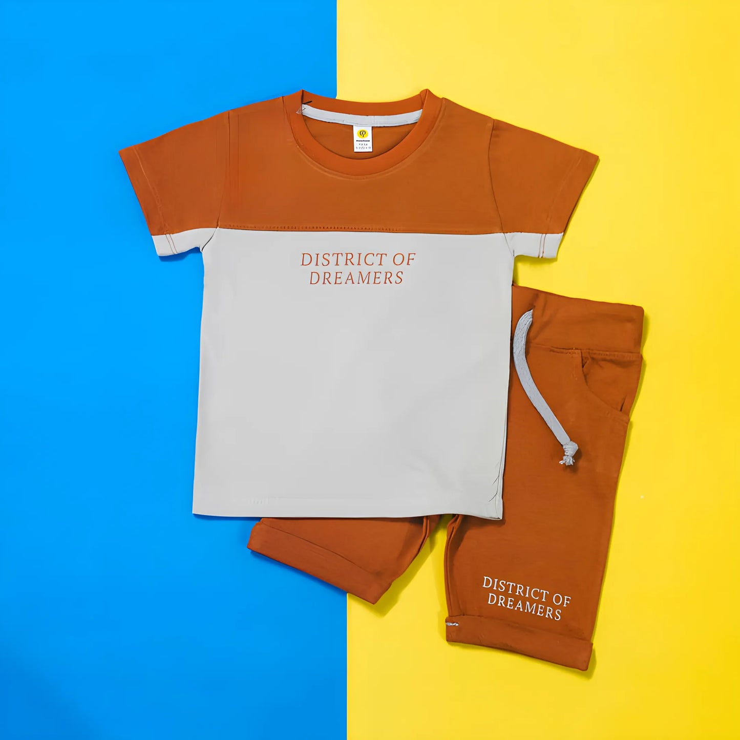 Children's t-shirt and shorts set with 'District of Dreamers' text on a blue and yellow background