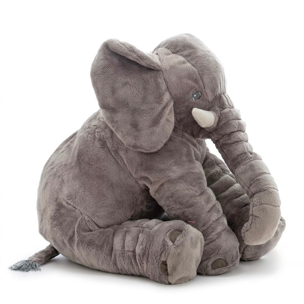 A plush gray elephant toy sitting down, featuring soft textured fabric, large floppy ears, a curled trunk, and small white tusks, photographed on a clean white background.