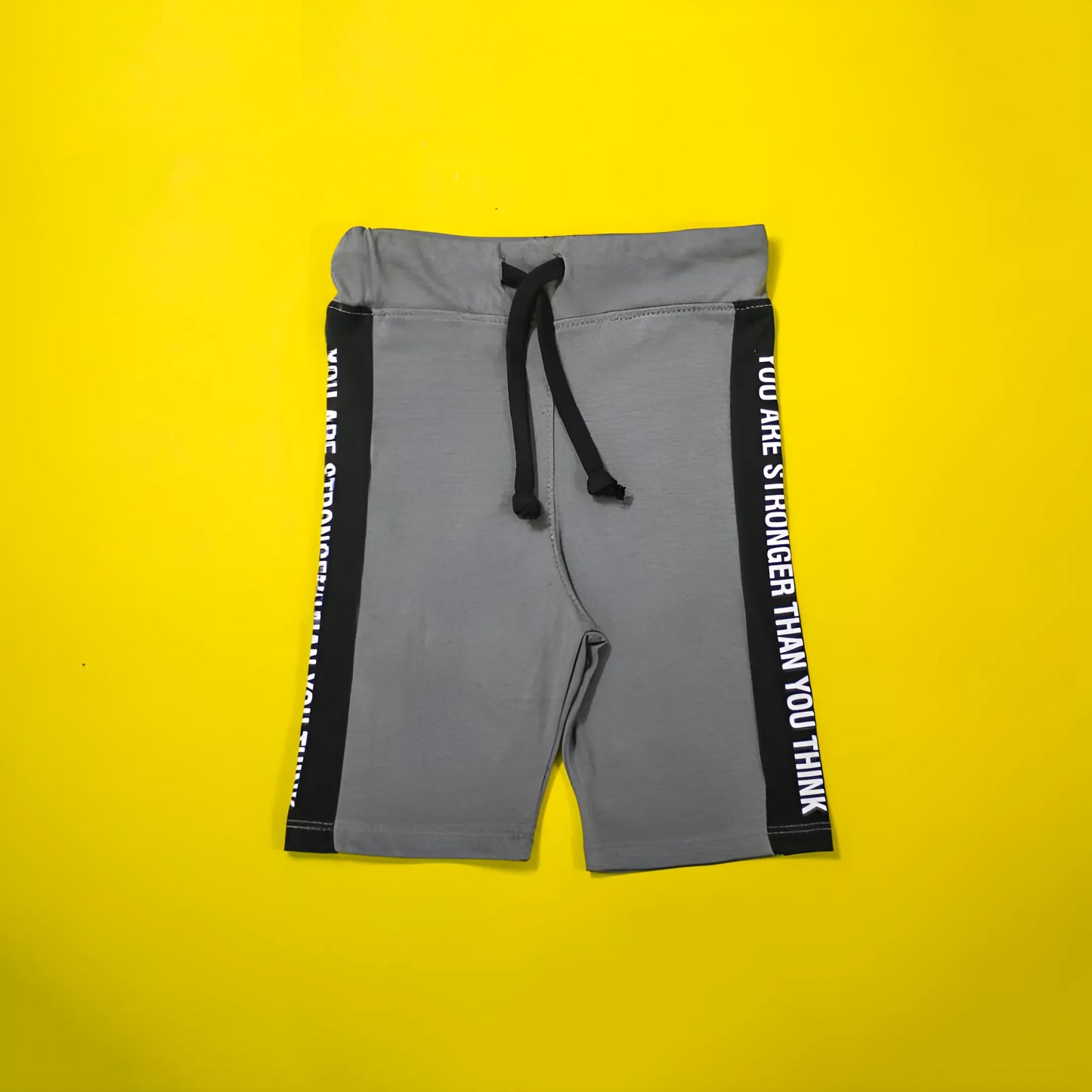 Gray shorts with black drawstring and text on a yellow background