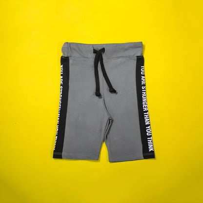 Gray shorts with black drawstring and text on a yellow background