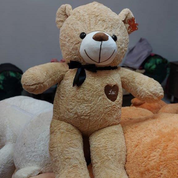 Plush teddy bear with heart design on a gray background