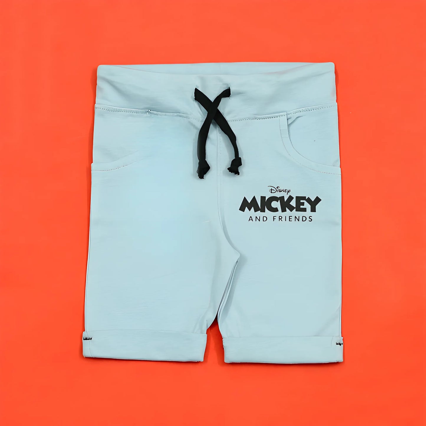 Light blue shorts with a black drawstring on an orange background, featuring Disney Mickey and Friends logo.