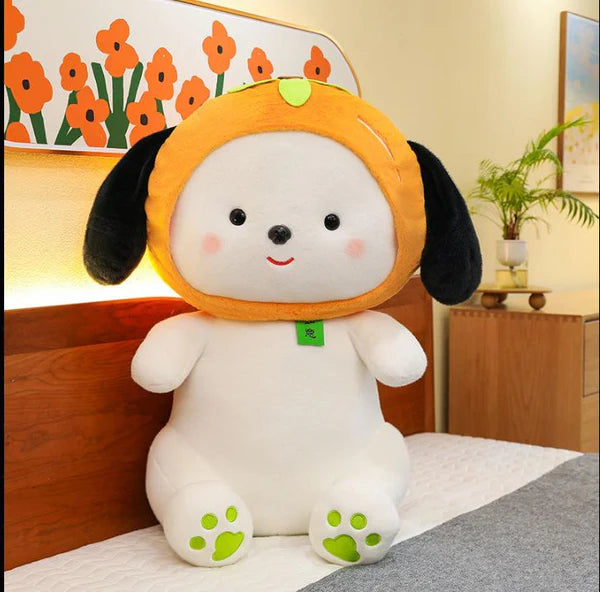 Plush toy dog in a yellow raincoat on a bed with a floral headboard.