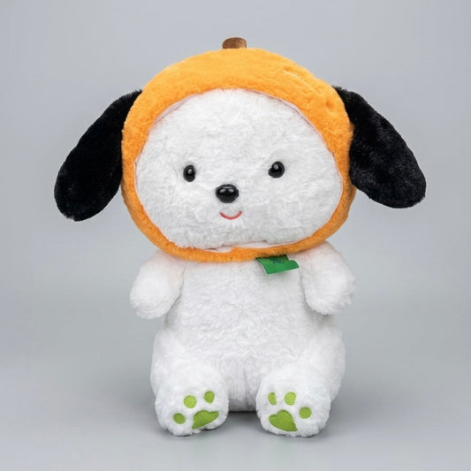 A white plush puppy toy wearing an orange pumpkin hat with black ears and a small green leaf accent, photographed against a light gray studio background.