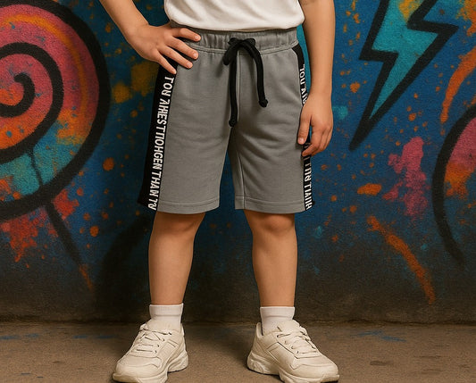 Person wearing gray shorts with text against a colorful graffiti wall.