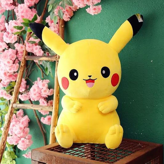 Plush toy Pikachu sitting on a wooden crate with pink flowers and greenery in the background