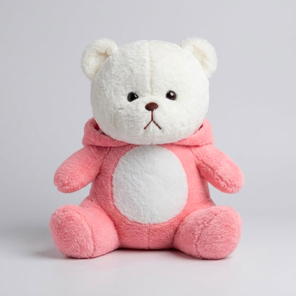 A plush teddy bear sitting upright, with a white face and ears, a pink body and hooded outfit, and small embroidered facial details on a light gray studio background.