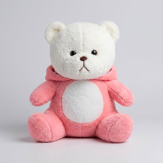 A plush teddy bear sitting upright, with a white face and ears, a pink body and hooded outfit, and small embroidered facial details on a light gray studio background.