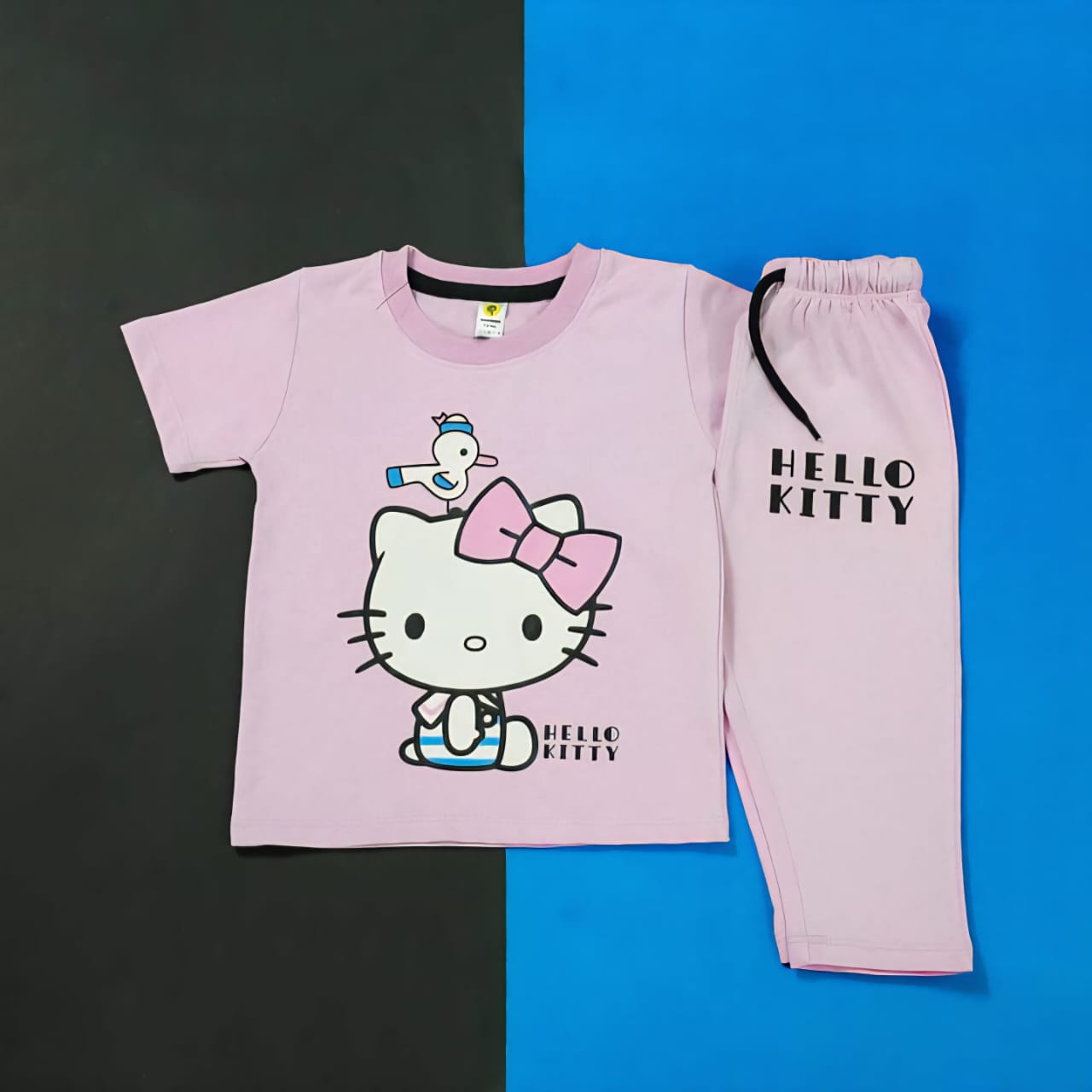 Pink 'Hello Kitty' pajama set on a black and blue background