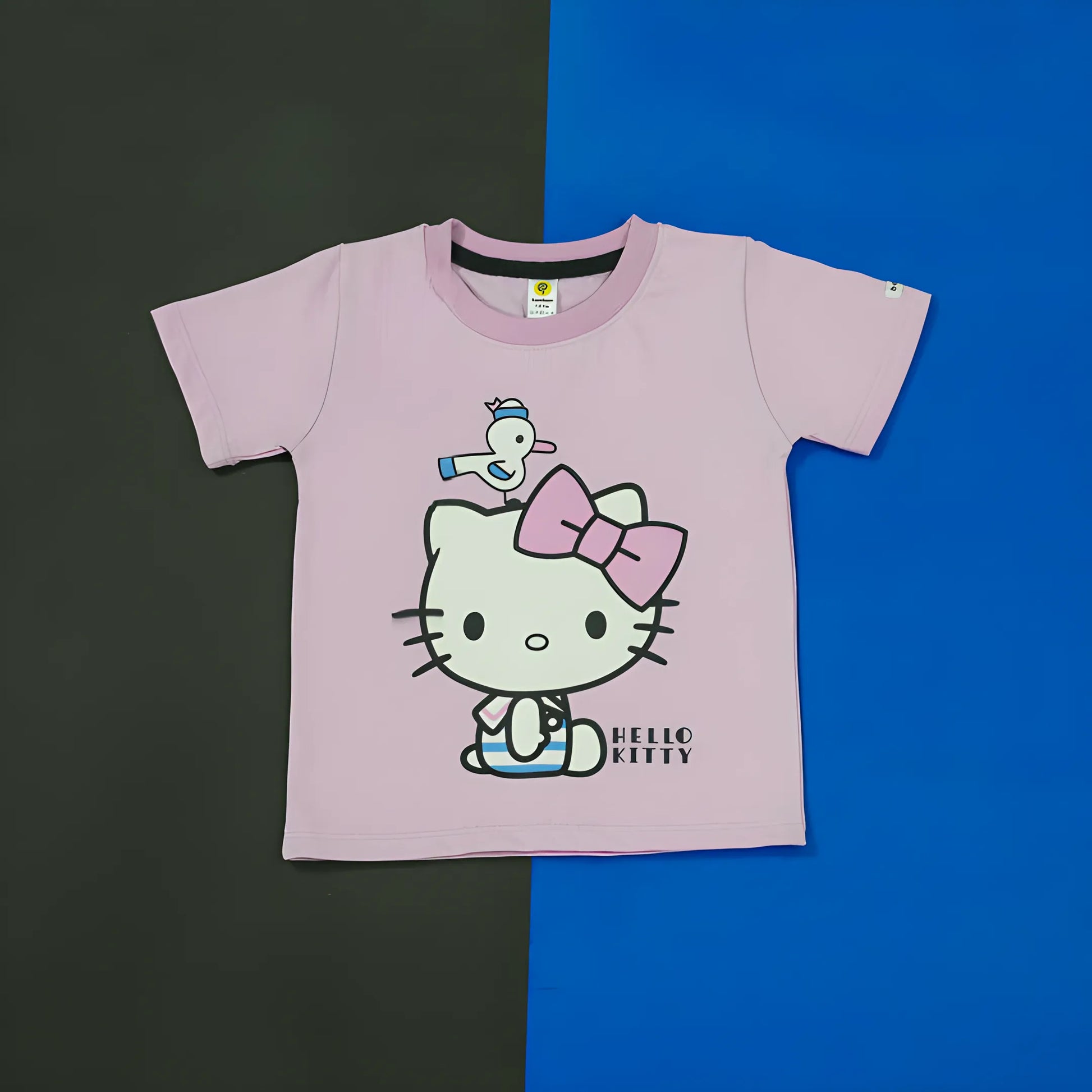 Pink t-shirt with Hello Kitty graphic on a black and blue background