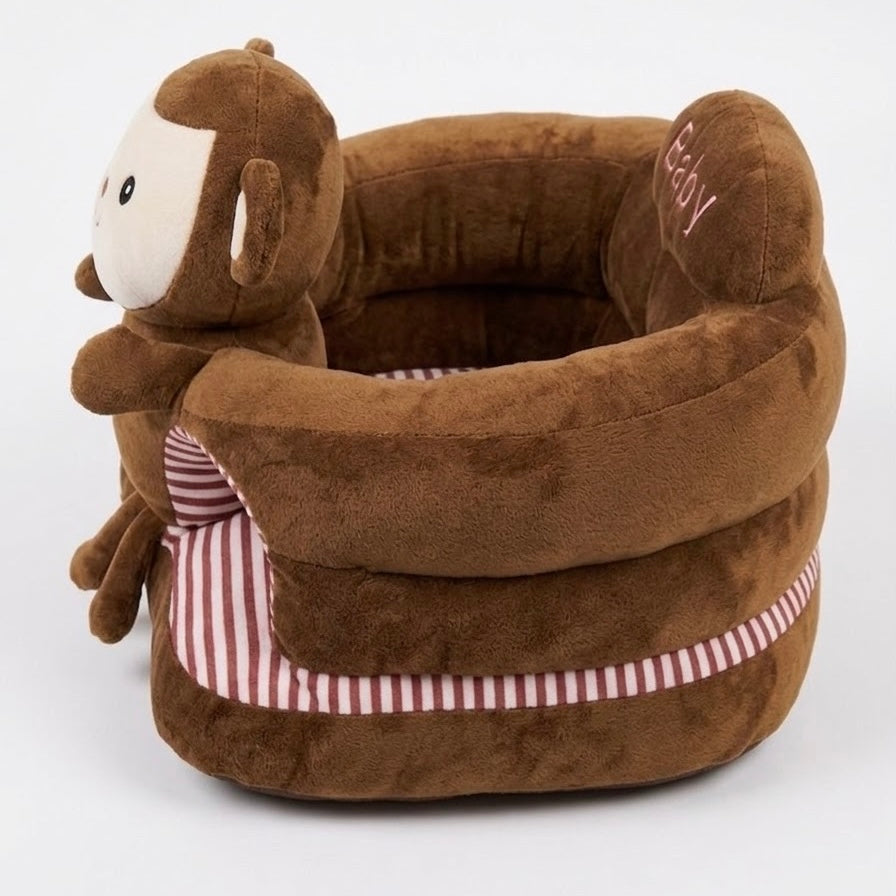 A plush brown monkey pet bed with a soft cushioned interior, red and white striped fabric accents, and embroidered pink lettering on the side, photographed on a clean white background.