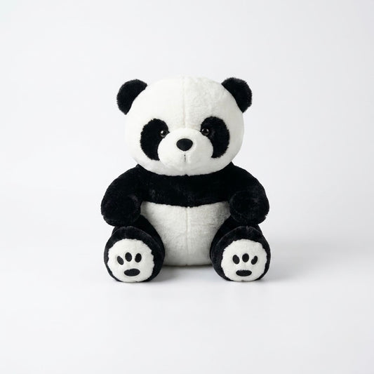 Front view of a soft black and white plush panda bear sitting against a clean white background