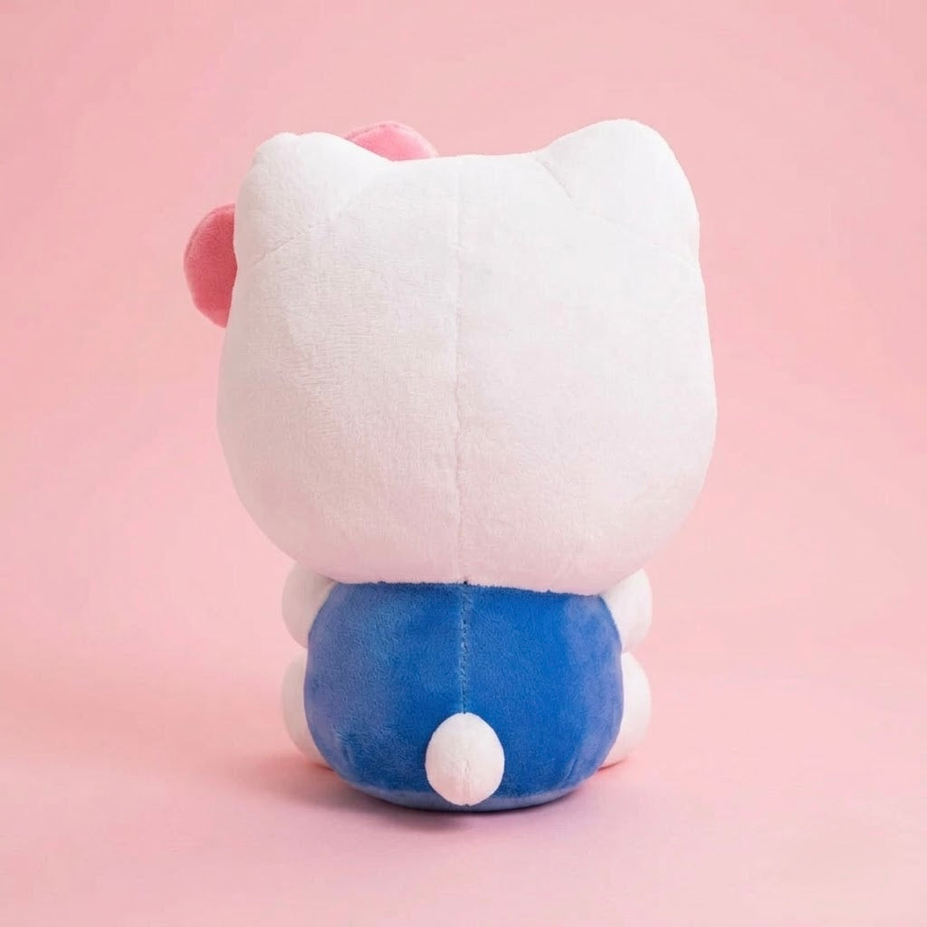 A plush toy shown from the back, featuring a large white head with pink inner ears, a blue body, and a small white tail, set against a solid pink background.